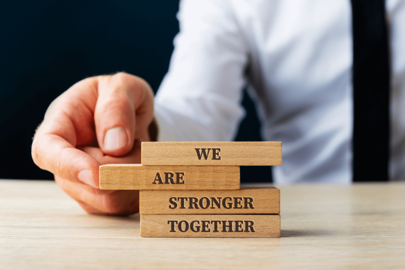 Man putting blocks together saying we are stronger together