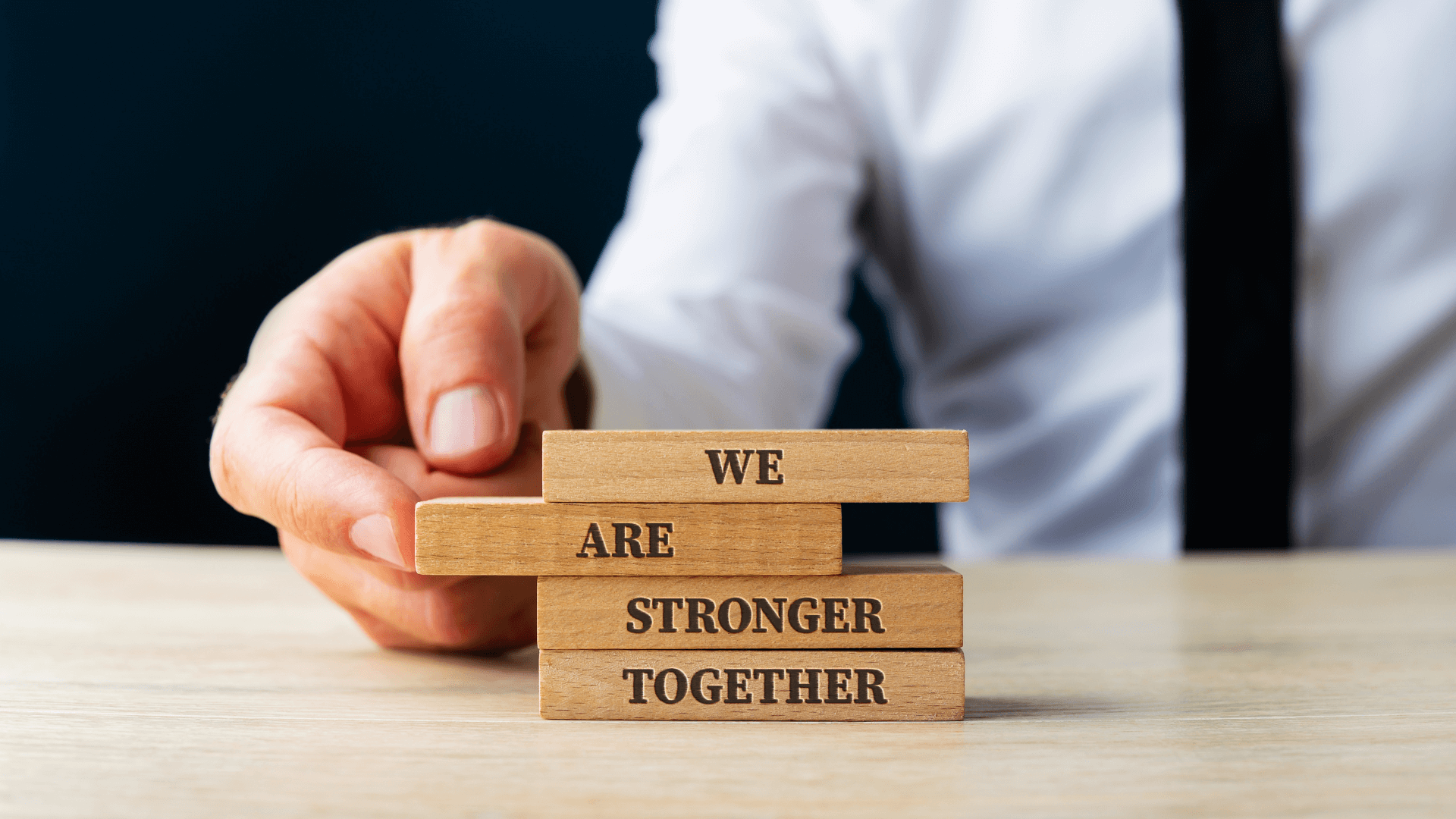 Man putting blocks together saying we are stronger together